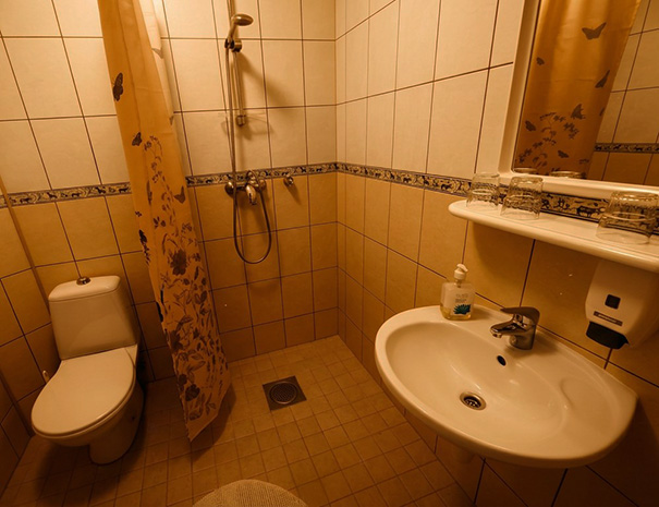 The spacious and bright private bathroom of the Family Suite at Hostel Lõuna, featuring a modern shower area and sink.
