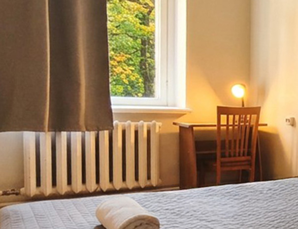 Hostel Lõuna ühekohalise toa aknaalune kirjutuslaud laualambiga.