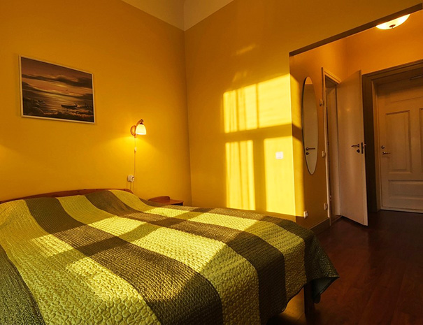Hostel Lõuna kahekohaline tuba laia voodiga, millest avaneb vaade esikusse ja privaatse vannitoa uksele.