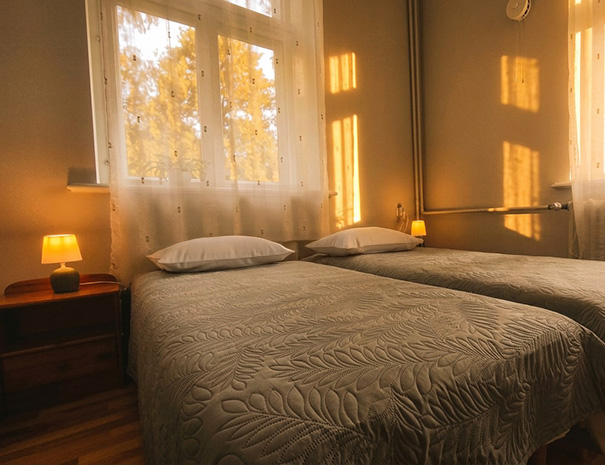 Üks Hostel Lõuna peresviidi kahest kahekohalisest magamistoast mugavate voodite, hubase valgustuse ja pargivaatega akendega.