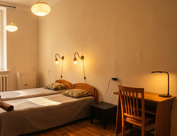 Hostel Lõuna 2. korruse twin tuba mugavate voodite, praktilise kirjutuslaua ja laualambiga.